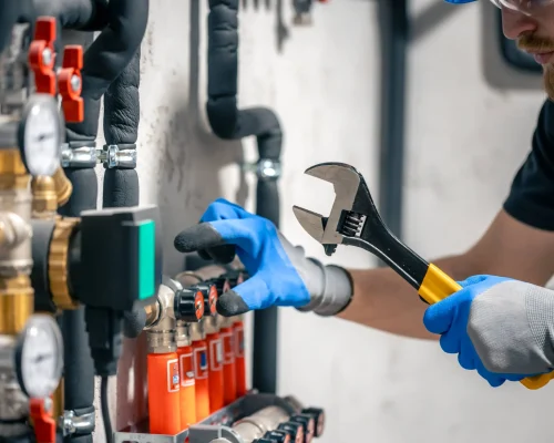 man-installs-heating-system-house-checks-pipes-with-wrench